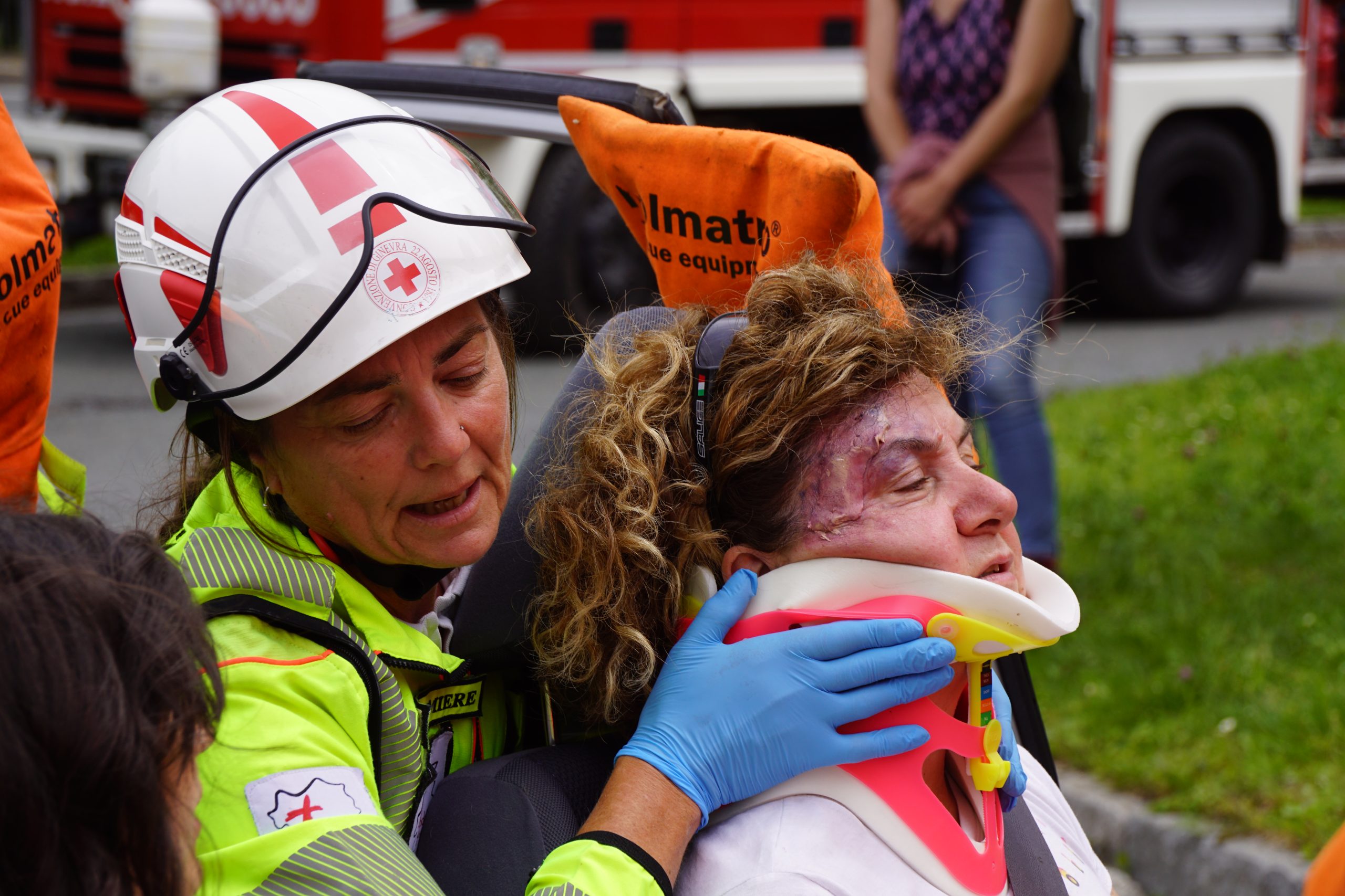 Infermiera tiene fermo un paziente col collare durante le operazioni di estrazione da un'auto accidentata