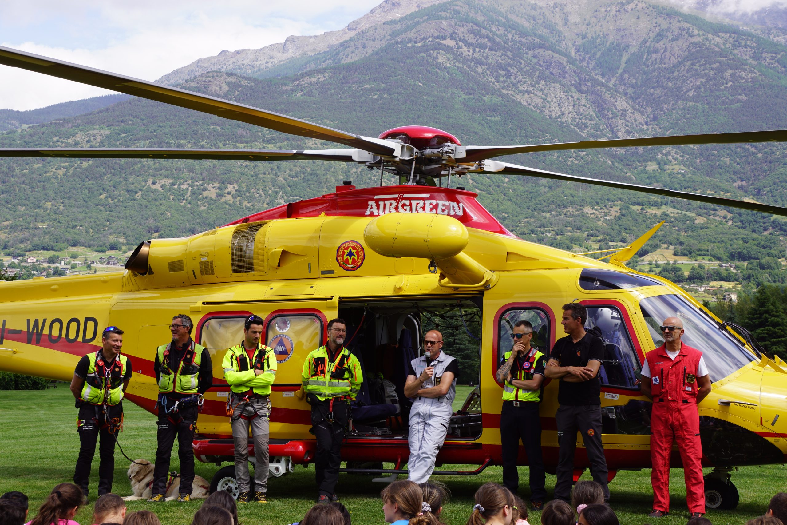 L'equipaggio dell'elisoccorso mentre illustra il proprio lavoro agli studenti davanti all'elicottero