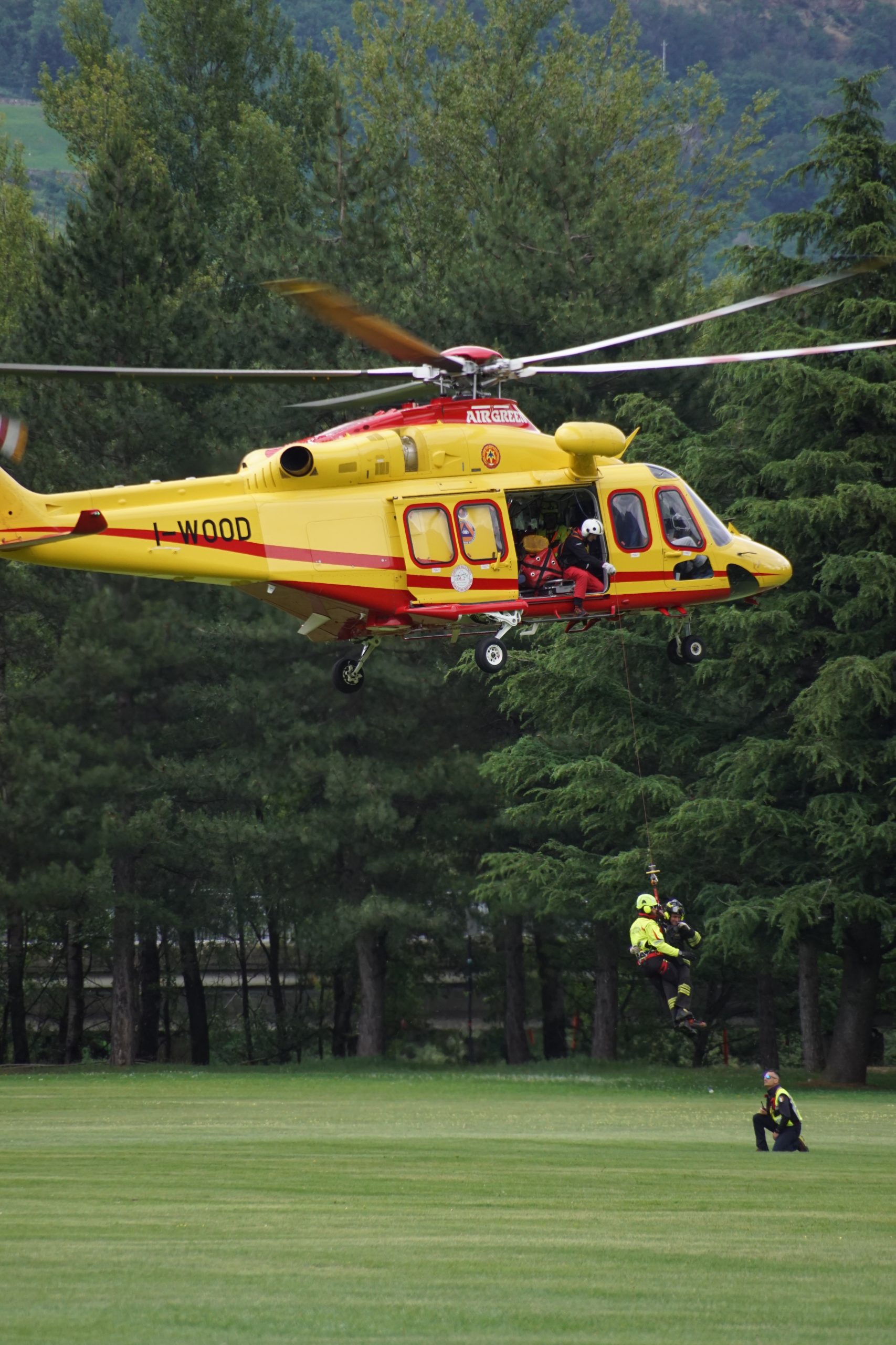 Elicottero sospeso a mezz'aria mentre vengono verricellati un tecnico del Soccorso Alpino Valdostano e un Vigile del Fuoco