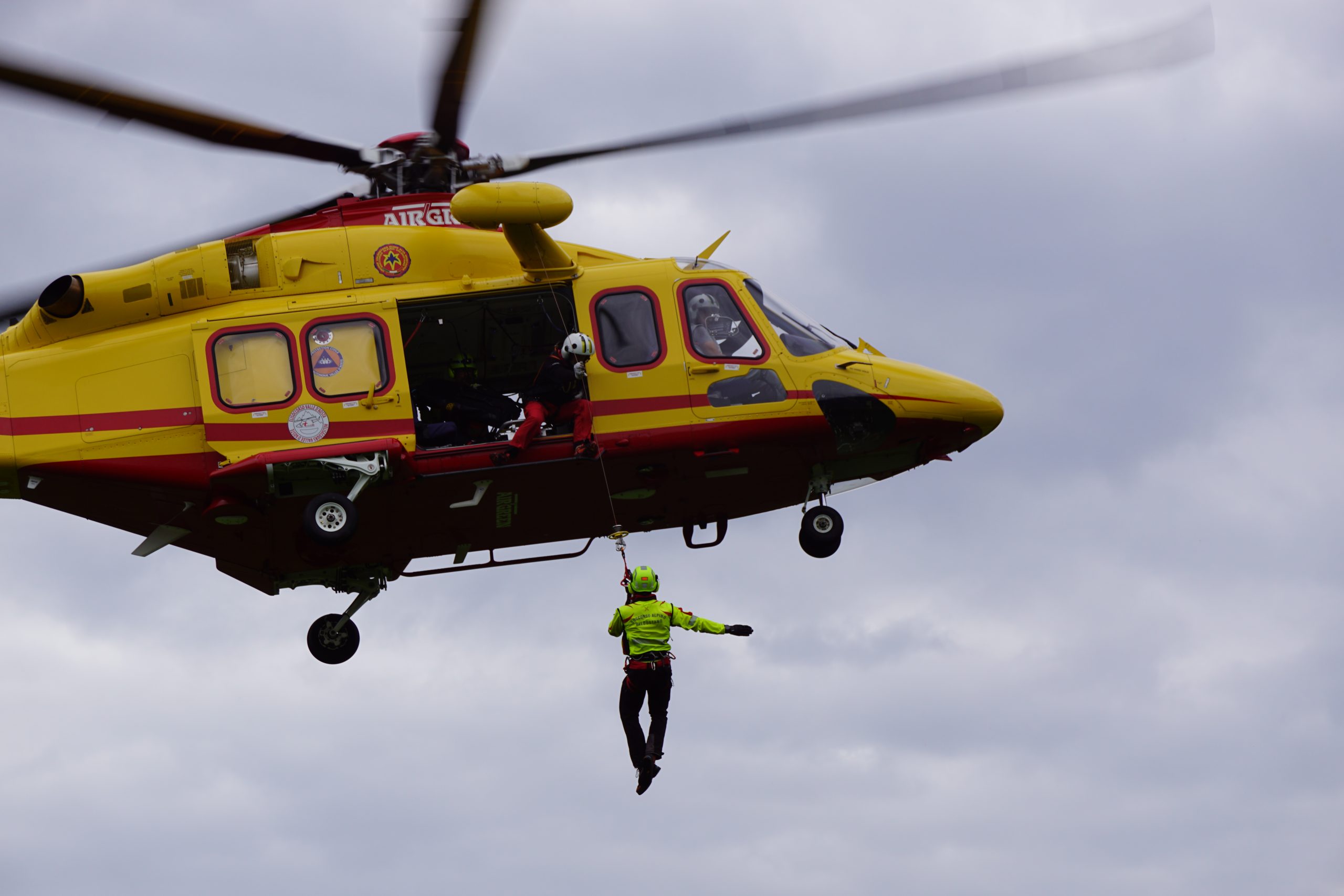 Tecnico del Soccorso Alpino Valdostano verricellato sotto all'elicottero del soccorso