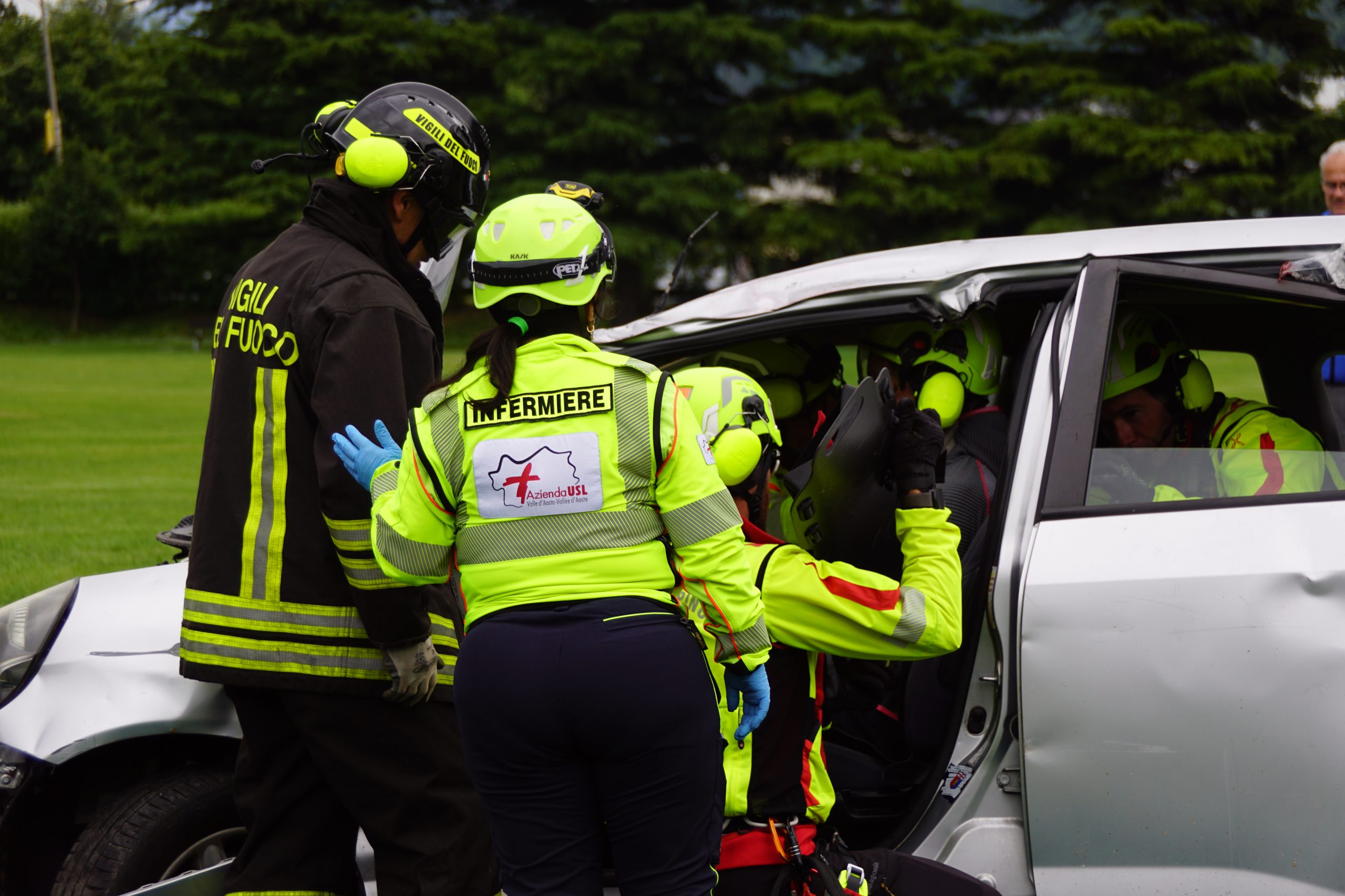Operatori del soccorso all'opera: infermiere, Vigile del Fuoco e tecnico del Soccorso Alpino Valdostano durante le manovre di estrazione di un ferito da un'auto accidentata