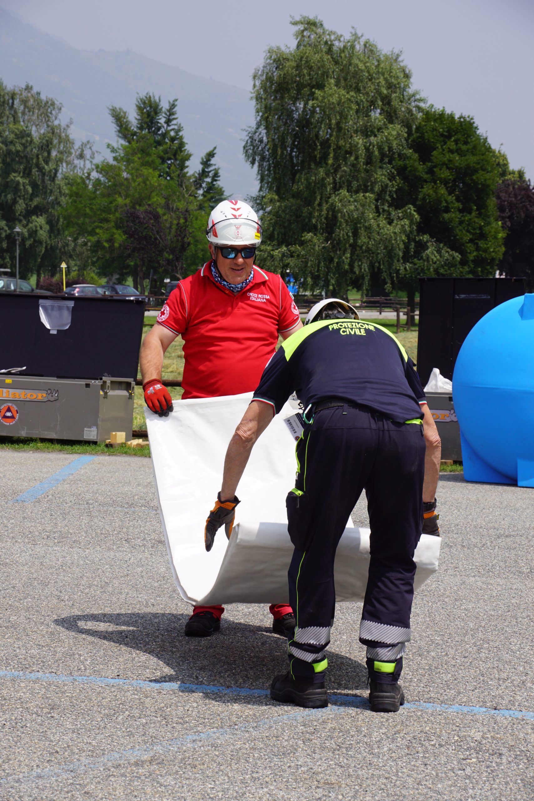 Due volontari mentre piegano i tendoni del padiglione ristorazione