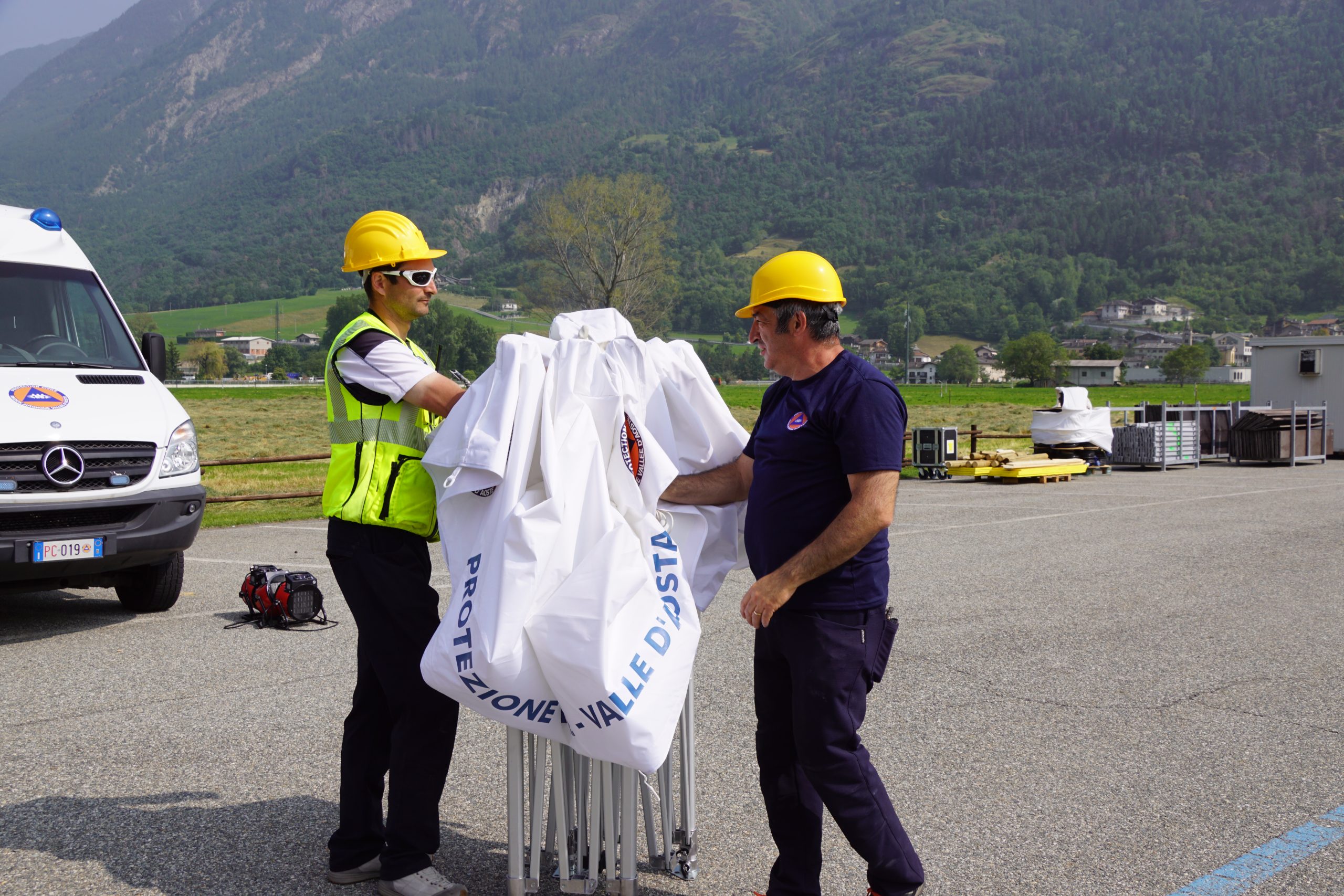 Due operatori di Protezione Civile mentre chiudono un gazebo